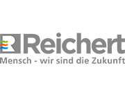 Reichert-Logo in Grau mit Slogan "Mensch - wir sind die Zukunft", Buchstabe R mit farbigen Linien.